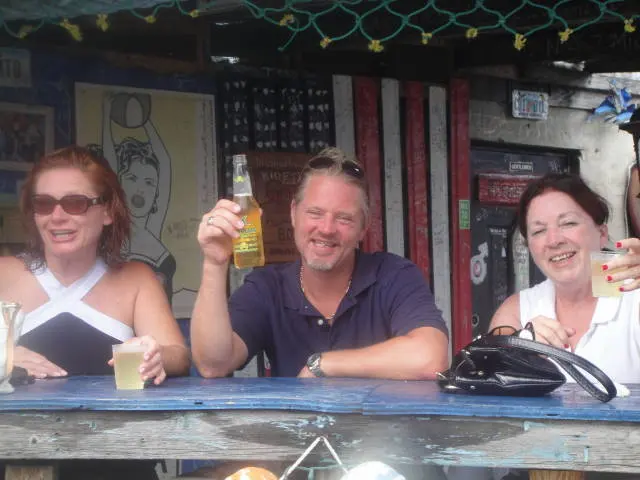 two women and a man at bar with drinks