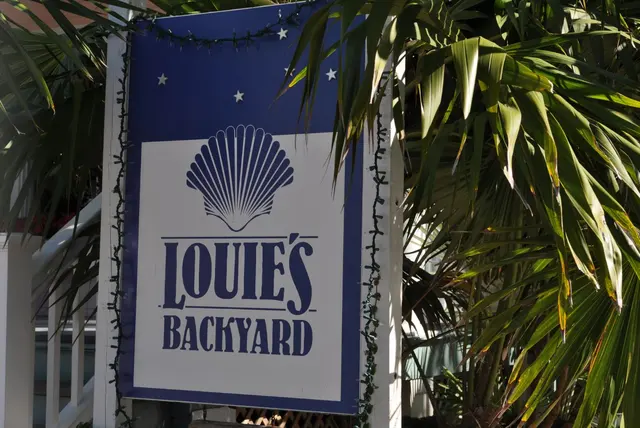 restaurant sign Louie's Backyard with palm trees