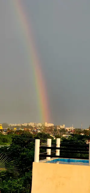 A rainbow arcs over the coastline after a passing morning shower.