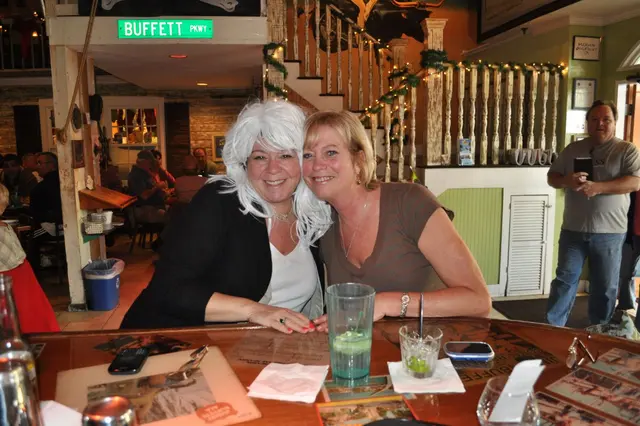 two women posing at bar one in white wig