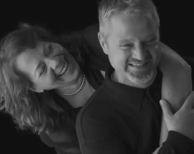 black and white studio portrait couple laughing clothed