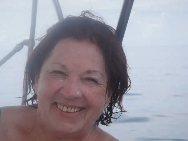 close crop of woman's face and bare shoulders in water; swimwear not visible in frame