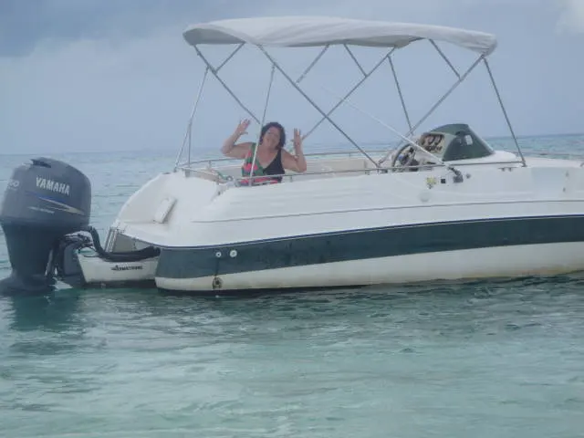woman on boat waving with peace signs