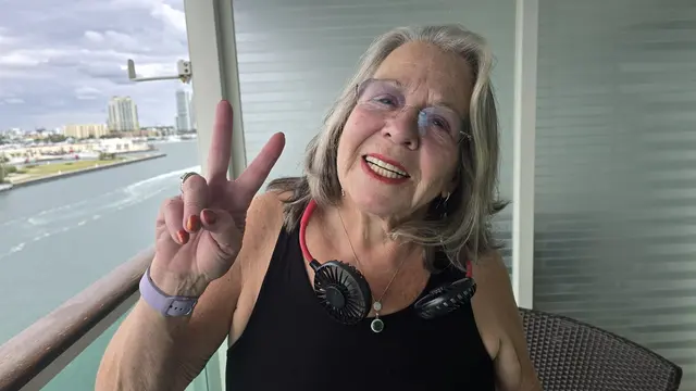 Lori giving a peace sign, all smiles at the start of the cruise.