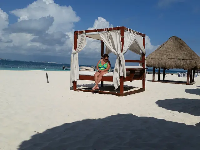woman sitting on beach cabana bed