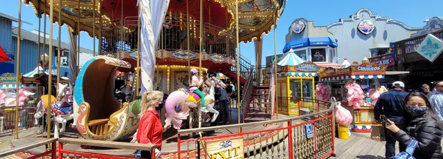 The historic double-decker carousel at Pier 39, lights glowing in the afternoon sun.