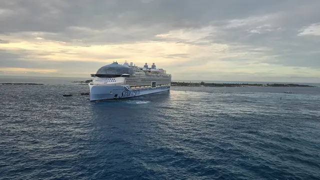 Sunrise at sea with another ship on the horizon.