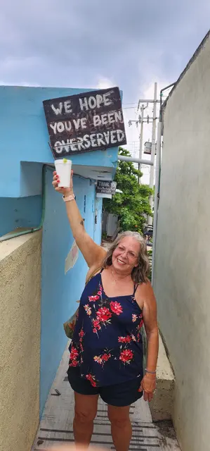 Lori clowning around at a beachside bar — "we hope you've been overserved."