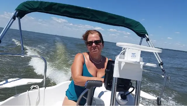 woman in swimsuit driving boat