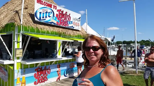 woman smiling at Jellyfish Joes bar sign