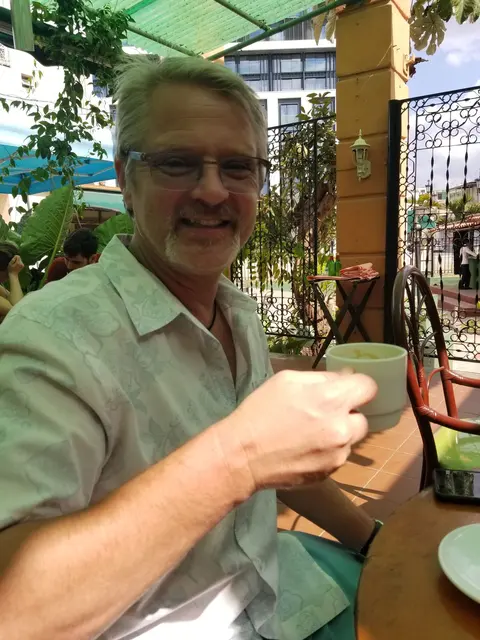 John enjoying a coffee break at a rooftop cafe