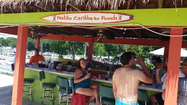people at outdoor tiki bar with drinks