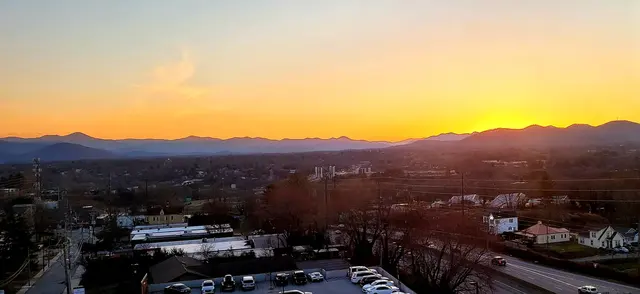 Golden hour over the Blue Ridge Mountains from a rooftop bar