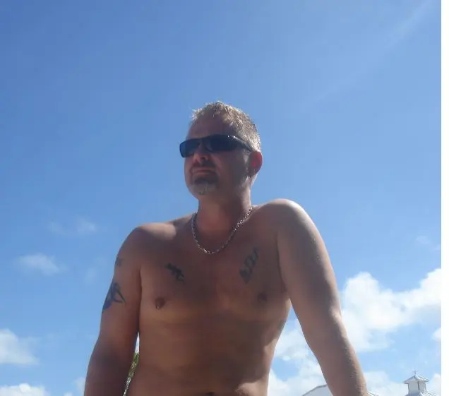 shirtless man in sunglasses outdoors