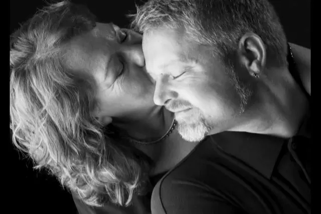black and white studio portrait couple embracing clothed