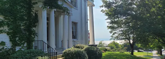 A grand white-columned building overlooking Lake Champlain