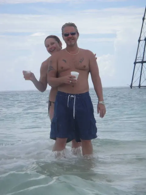man and woman in water near lighthouse