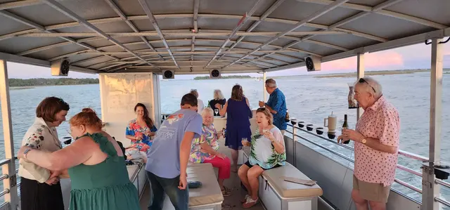 Raising a glass as the sun sets on the water