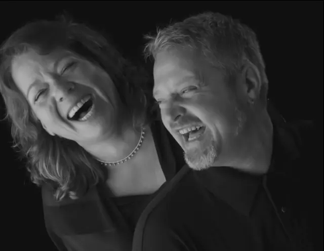 black and white studio portrait couple laughing clothed