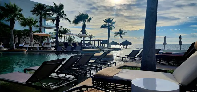 Empty loungers and quiet water — a peaceful morning by the resort pool.