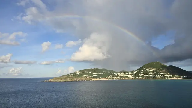 A brilliant full rainbow arcing over the water near St. Maarten.