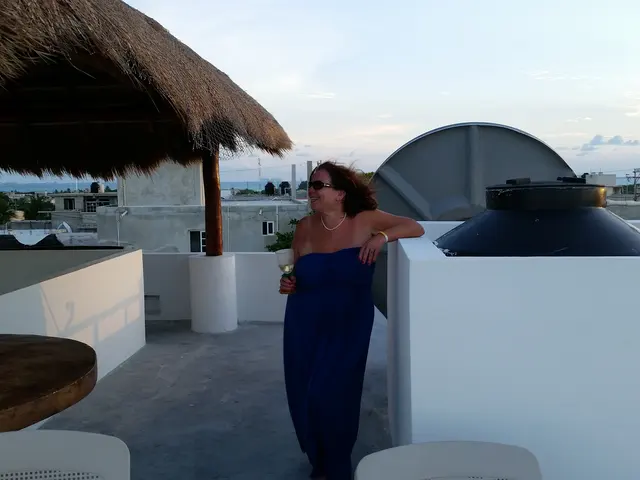 woman in blue dress on rooftop terrace at dusk