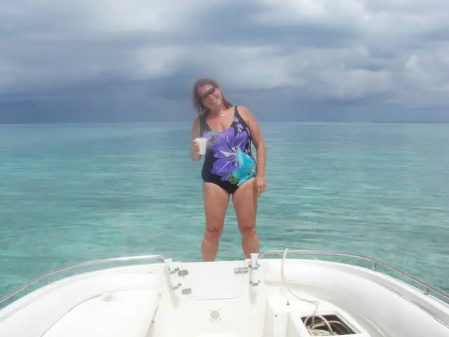 woman in swimsuit standing on boat bow
