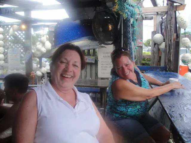 two women smiling at outdoor bar