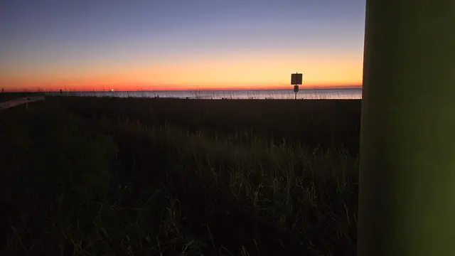 A quirky red phone booth lit up at night.