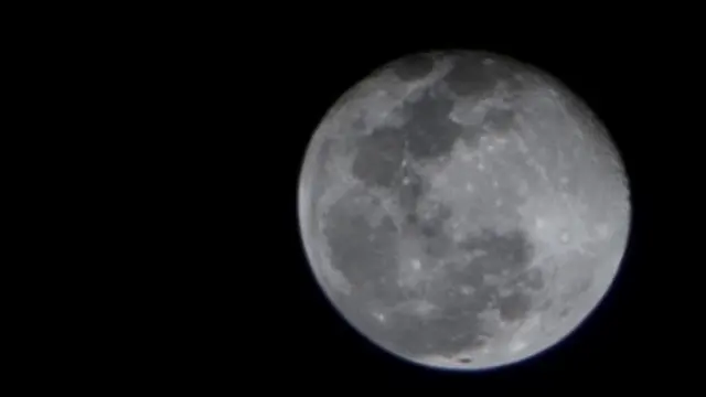 A crisp full moon over the Atlantic on a clear night at sea.