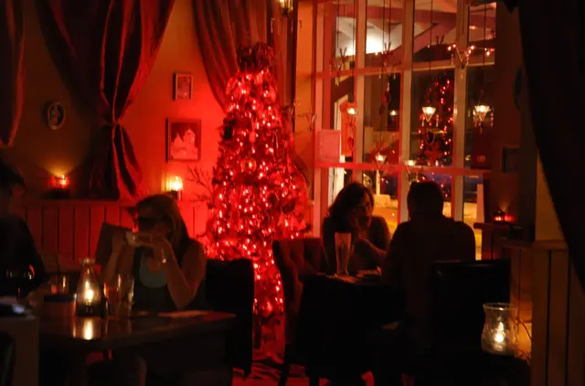people dining at restaurant with Christmas tree