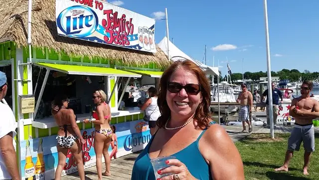 woman smiling near bar with marina background