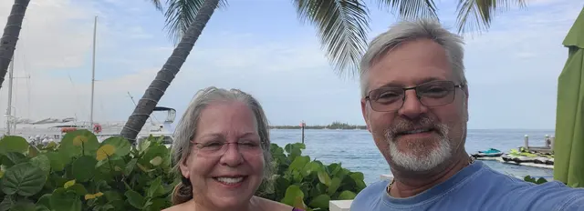 John and Lori with the harbor and palms behind them