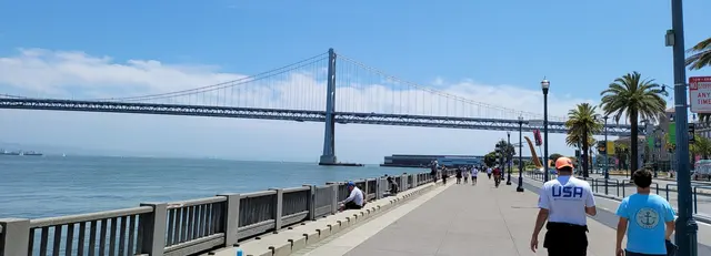 Strolling the Embarcadero waterfront with the Bay Bridge stretching overhead.