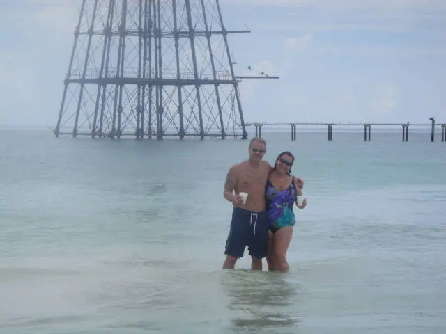 couple standing in water near offshore structure
