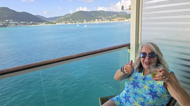 Lori giving a thumbs up from the balcony as the ship departs St. Maarten.