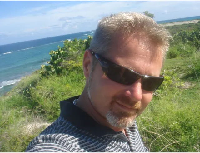 man selfie with ocean and greenery background