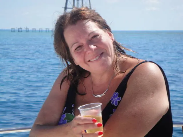 woman smiling on boat holding drink