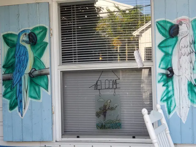 Colorful painted parrots on a shuttered Key West cottage.