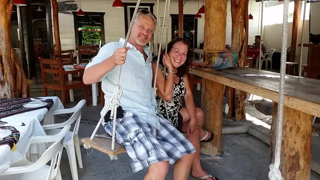 couple sitting on rope swing at restaurant