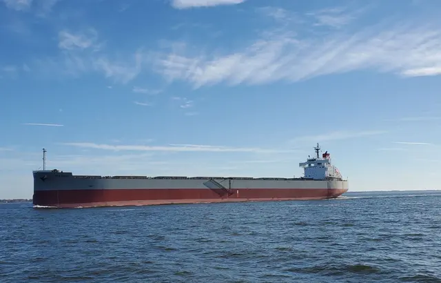 Large red and white cargo ship Oratorio on open water; scenery